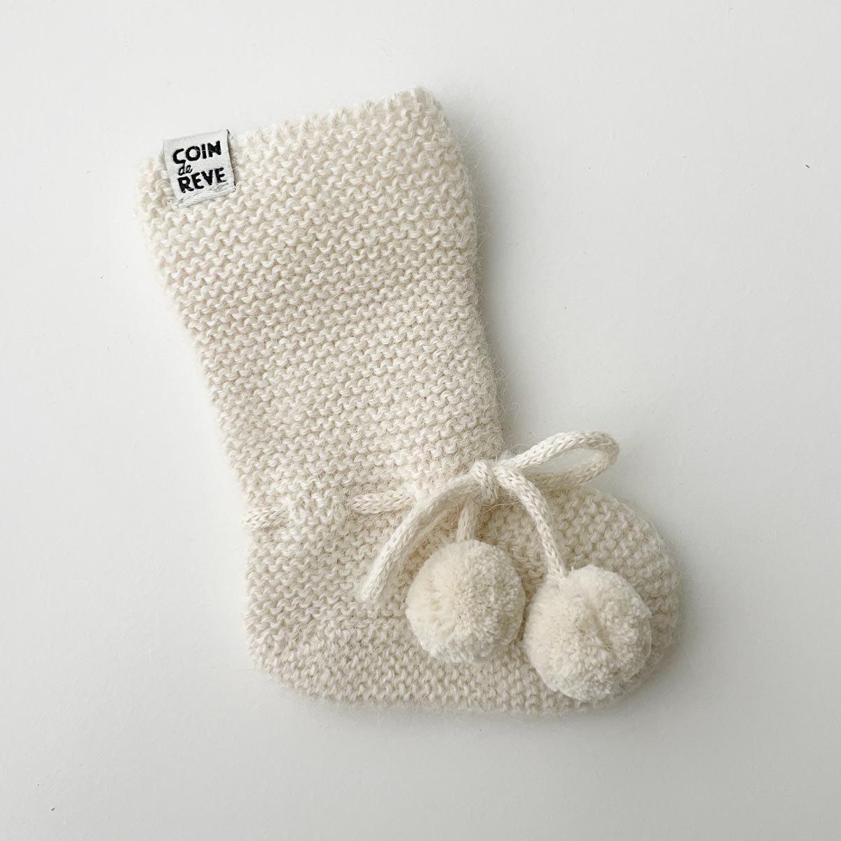 Uppvikt stickad strumpa för baby i naturvit alpacka-ull
