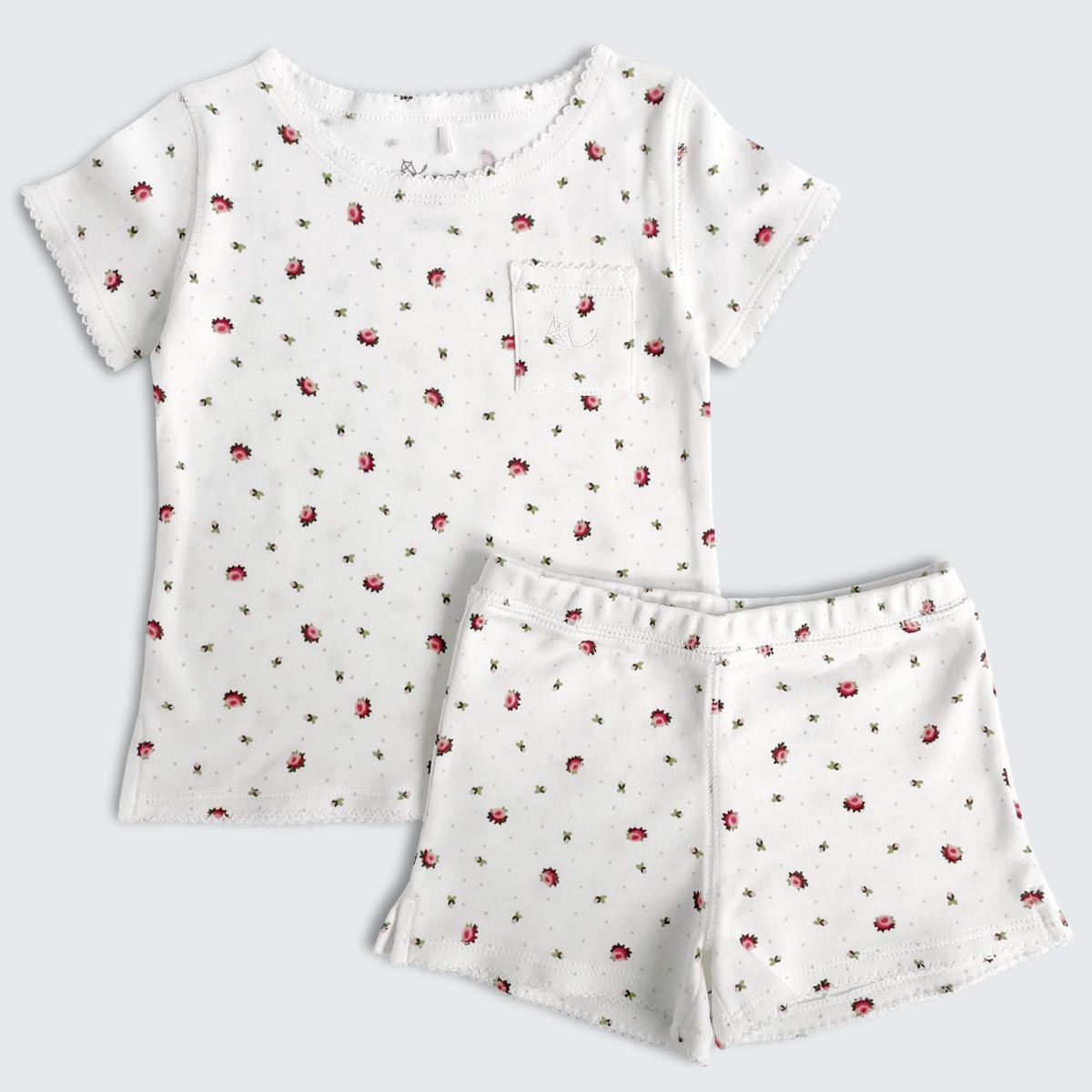 Kortärmad Pyjamas med shorts i ekologisk bomull. Krämvit bangrund med blommönster i vackra färger.