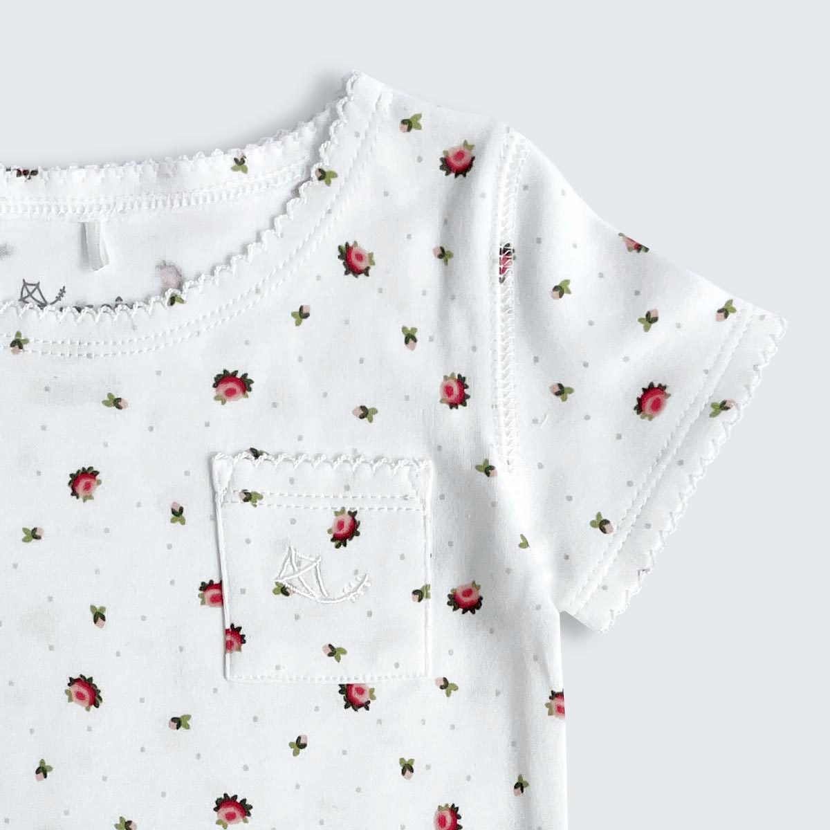 Detalj från kortärmad krämvit pyjamas i ekologisk bomull.