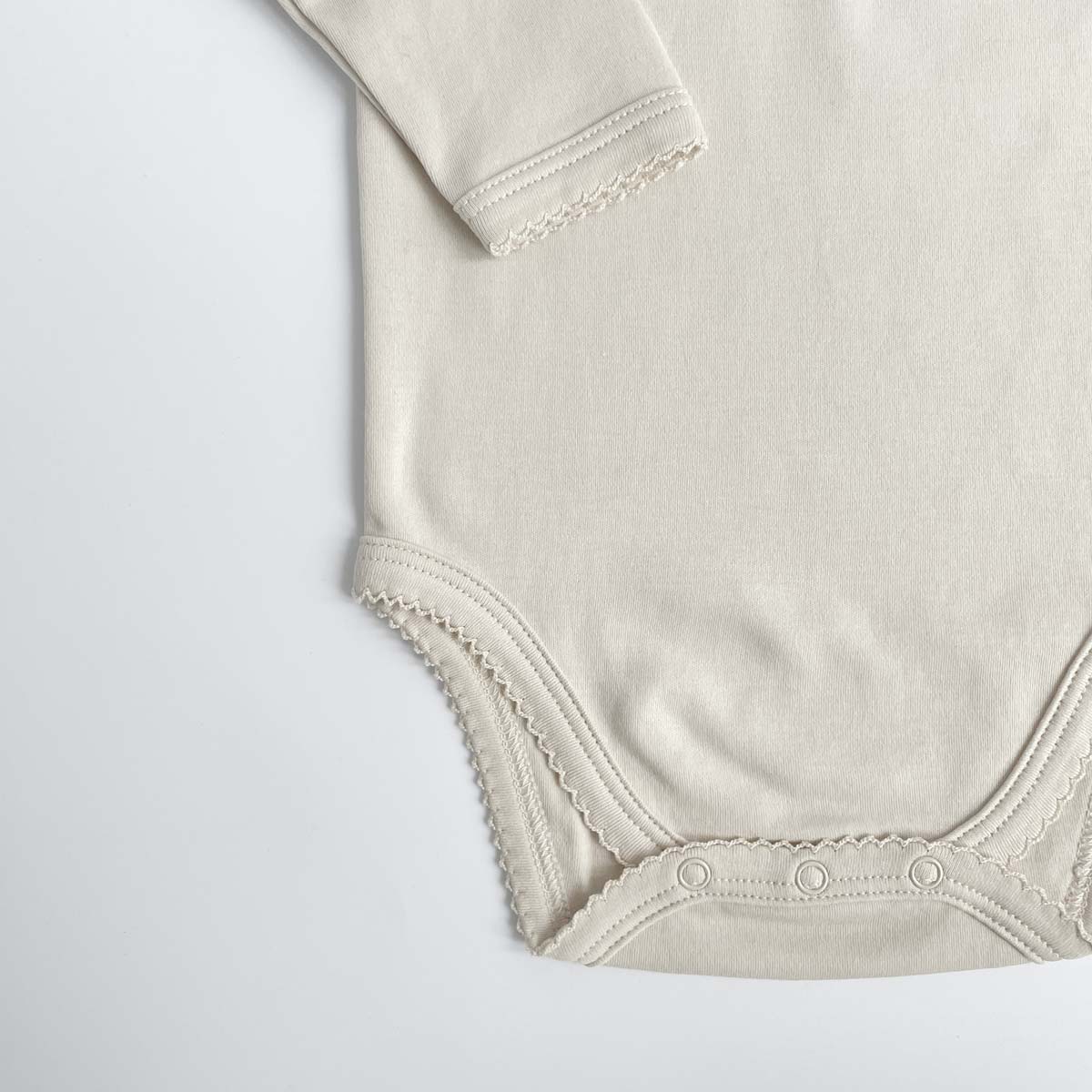 Detalj från greige body med spetskant