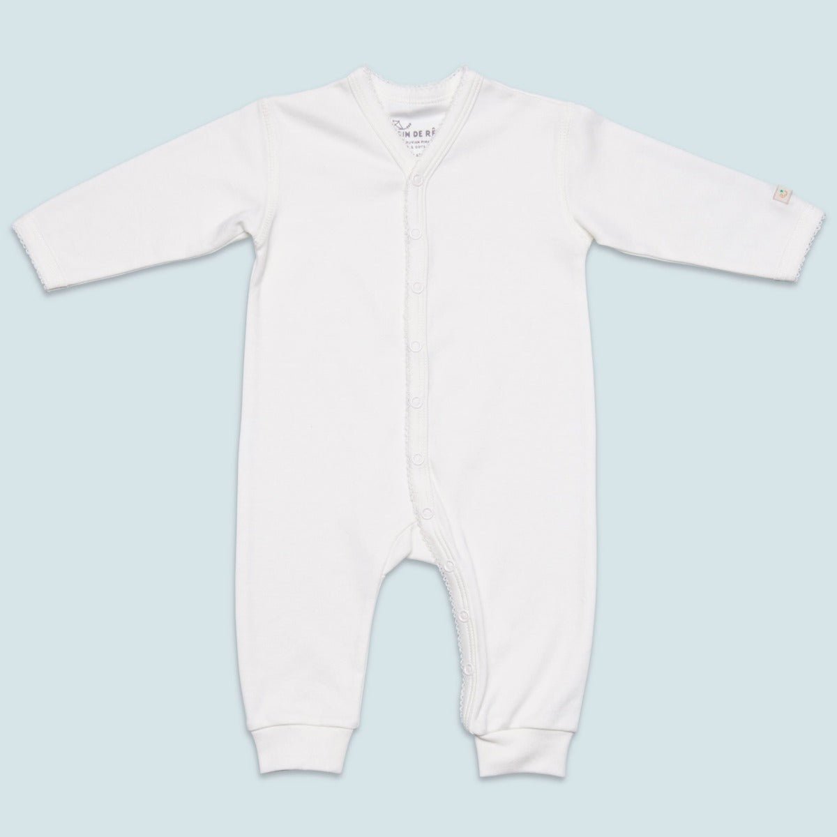 Krämvit jumpsuit för baby i supermjuk ekologisk pimabomull