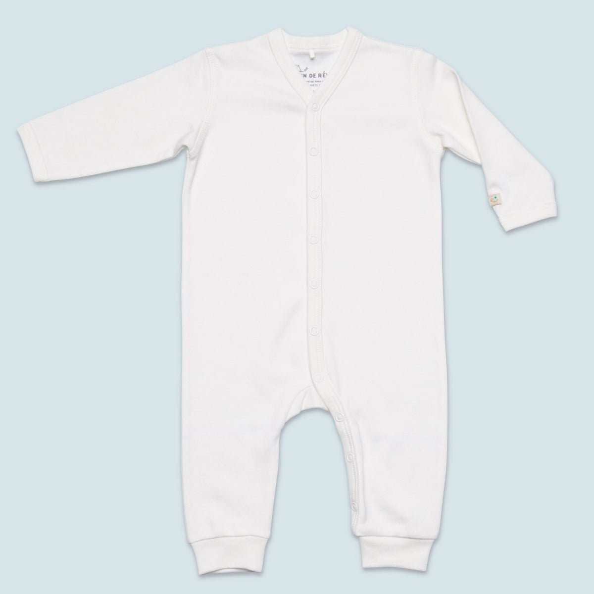 Krämvit jumpsuit för baby i supermjuk ekologisk pimabomull