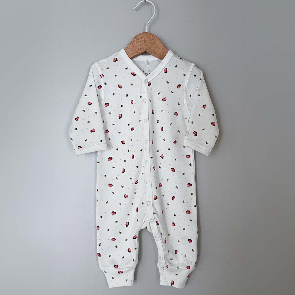 Krämvit blommig jumpsuit för baby i ekologisk och GOTS-certifierad bomull