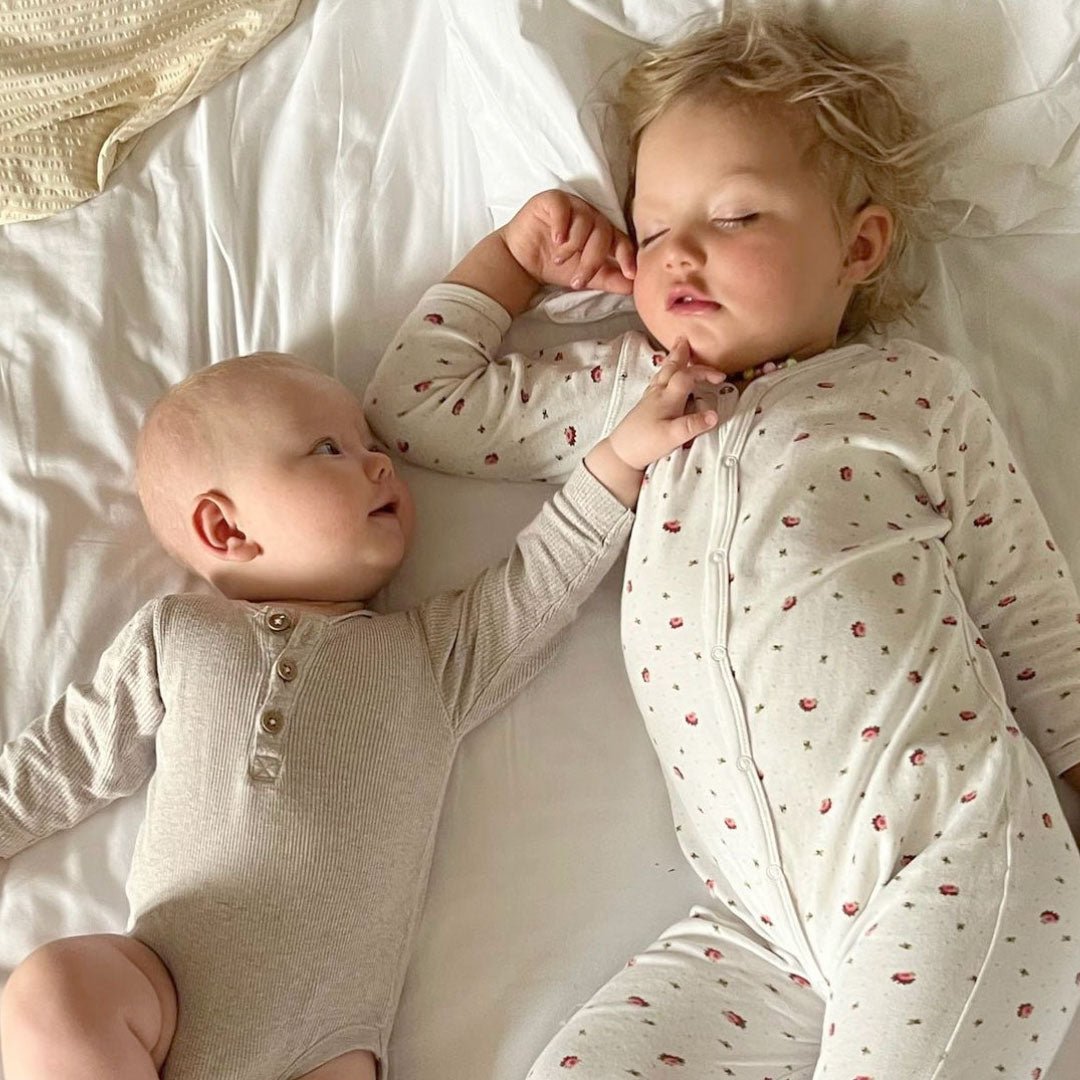 Sovande flicka i jumpsuit i ekologisk och GOTS-certifierad bomull med blommigt print