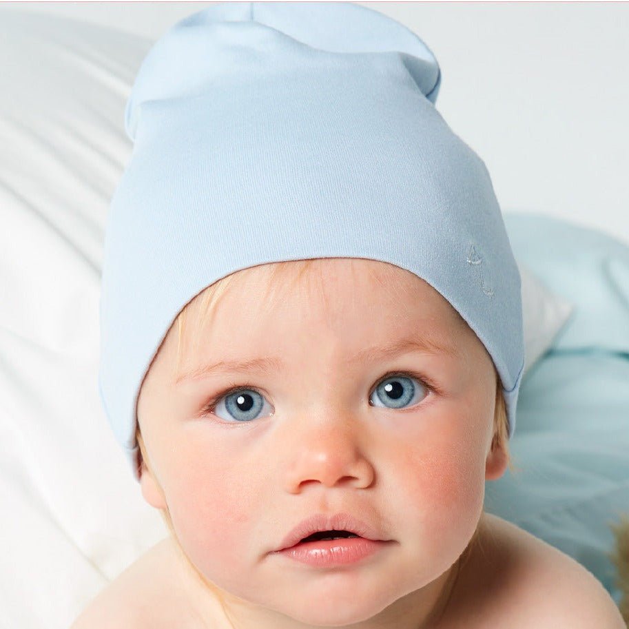 Flicka i söt ljusblå mössa av mjuk pimabomull