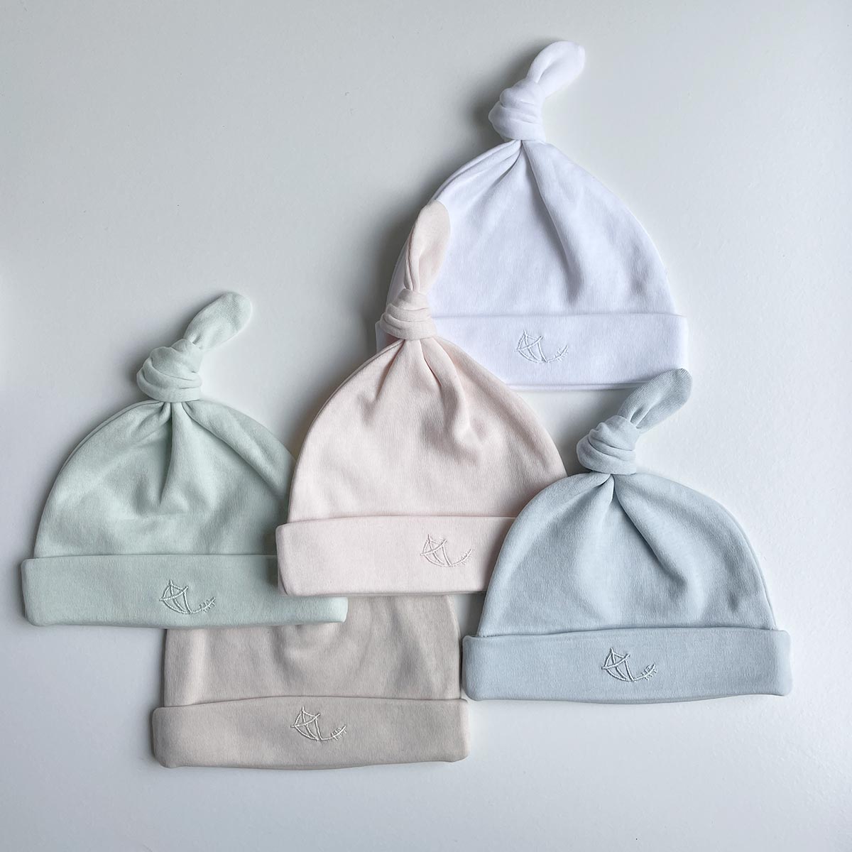 Babymössor i olika färger med knut i mjuk ekologisk pimabomull