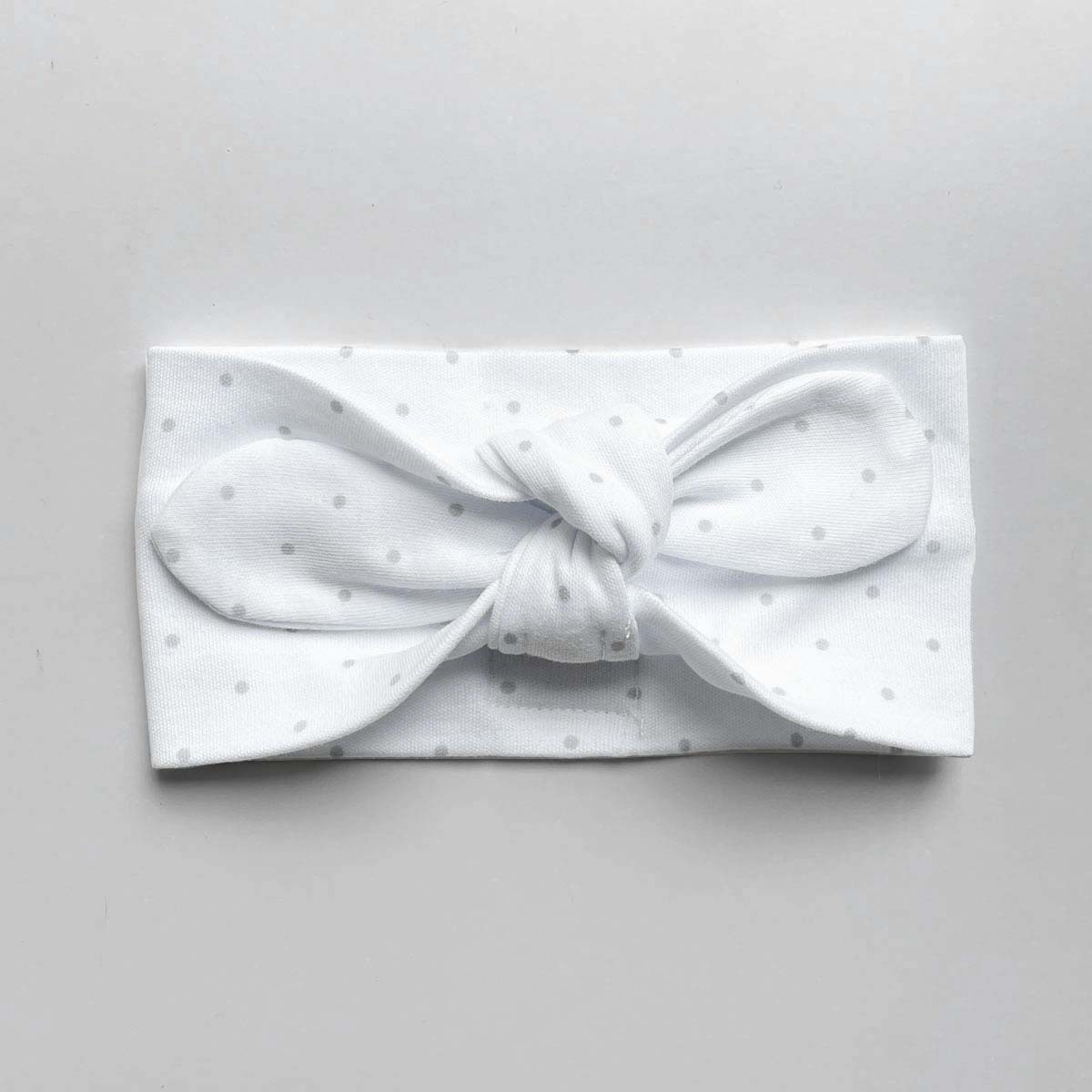 Vitt hårband med grå prickar för baby i ekologisk bomull med knut fram
