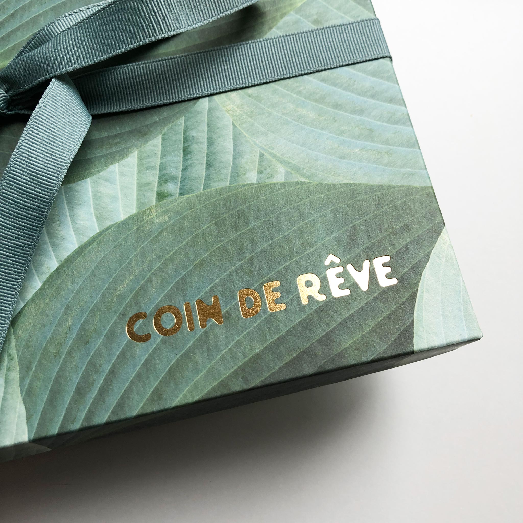 Lyxig presentlåda i grönt med vackert mönster och Coin de Rêve logo i guld