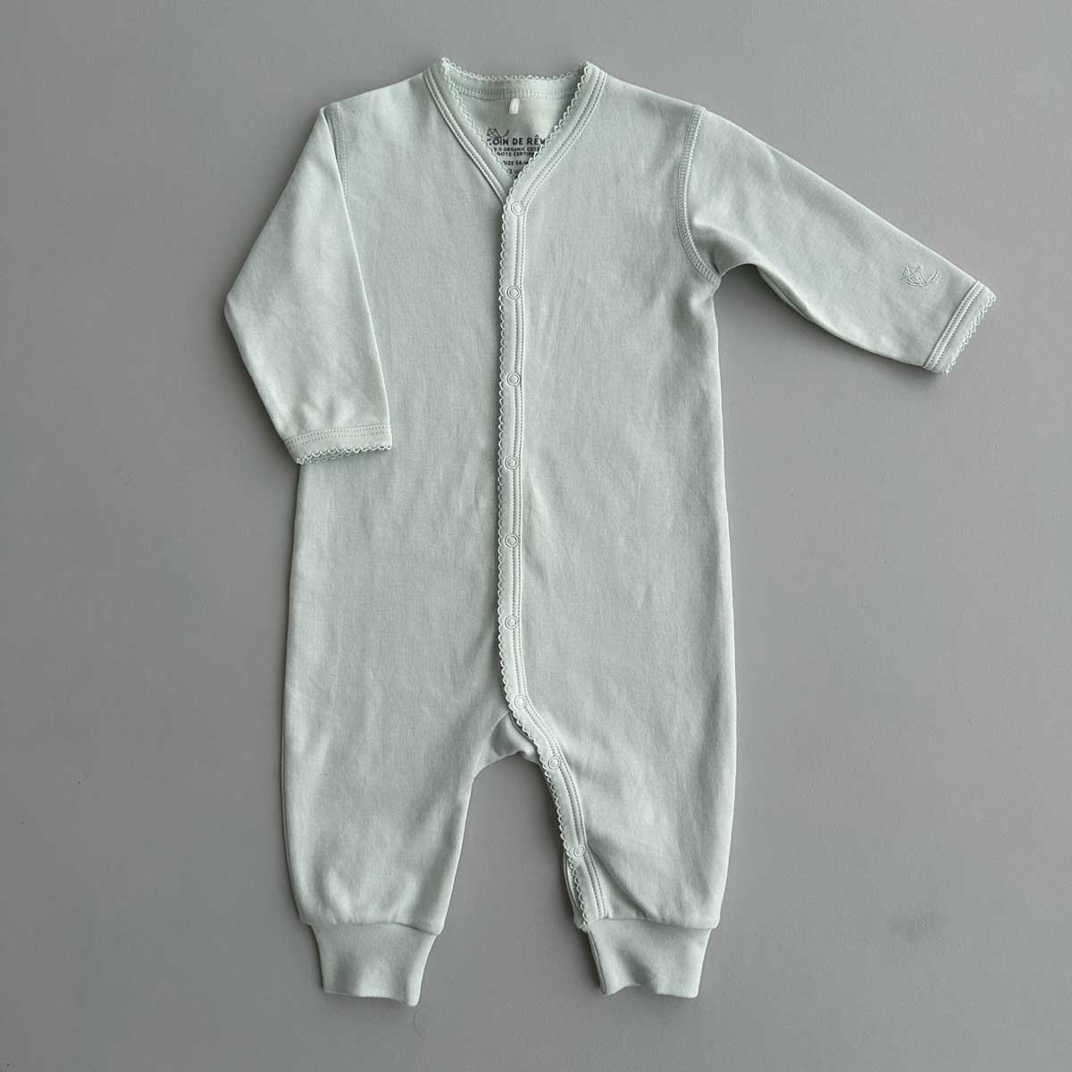 Mintfärgad jumpsuit med spetskant för baby i mjuk GOTS-certifierad pimabomull